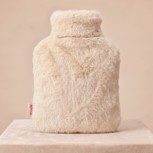 Beige fluffy hot water bottle on a beige background